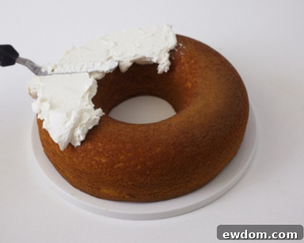 Step 8: Icing the donut cake with a thick layer of buttercream, creating a rough, nest-like texture.