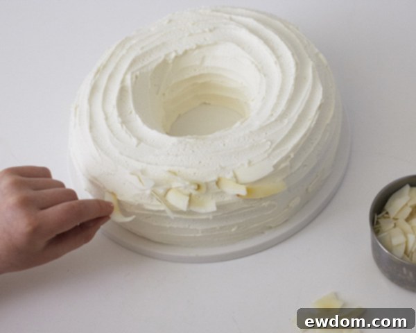 Step 9: Carefully placing individual toasted coconut chips onto the buttercream to form the nest.