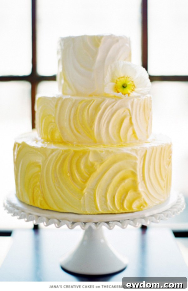 Ultra cheery cake with artistic swirls of yellow fading to white by Jana Richardson of Jana's Creative Cakes, for a serene and joyful occasion.