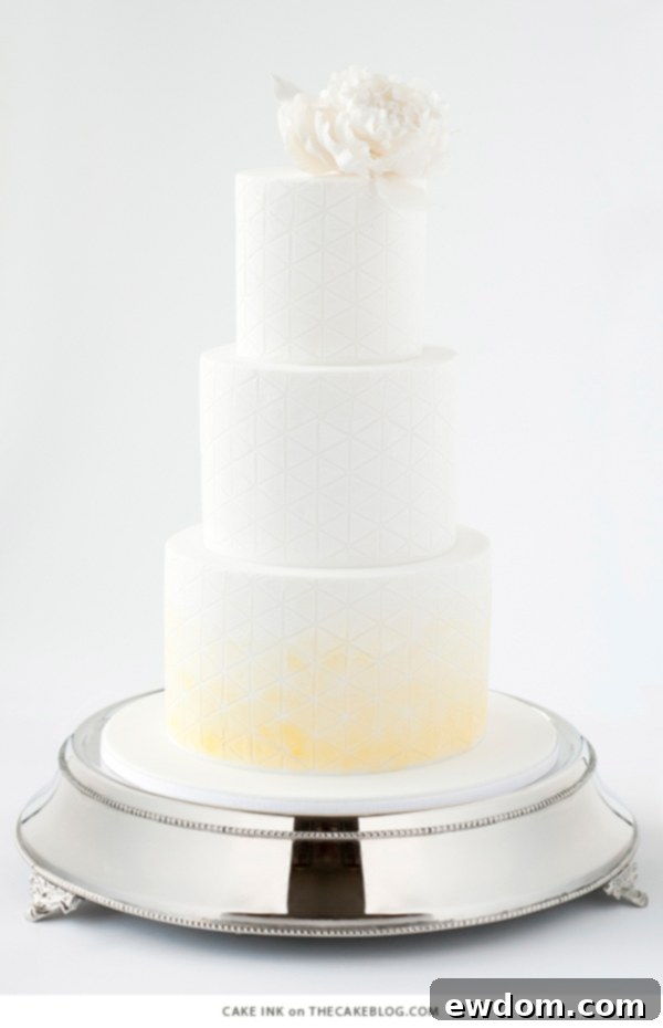 Modern elegant cake with white triangles delicately dusted with subtle yellow by Cake Ink, showcasing minimalist design for sophisticated events.