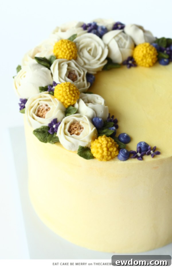 Cheerful single-tier buttercream cake with soft golden glow, adorned with gorgeous buttercream roses and billy balls by Eat Cake Be Merry.