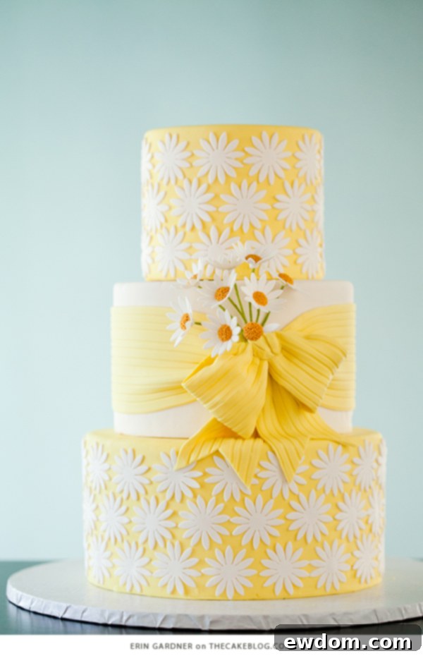 Lovable daisy patterned cake with yellow fondant bow and sugar daisy cluster, inspired by 'he loves me, he loves me not' game by Erin Gardner.