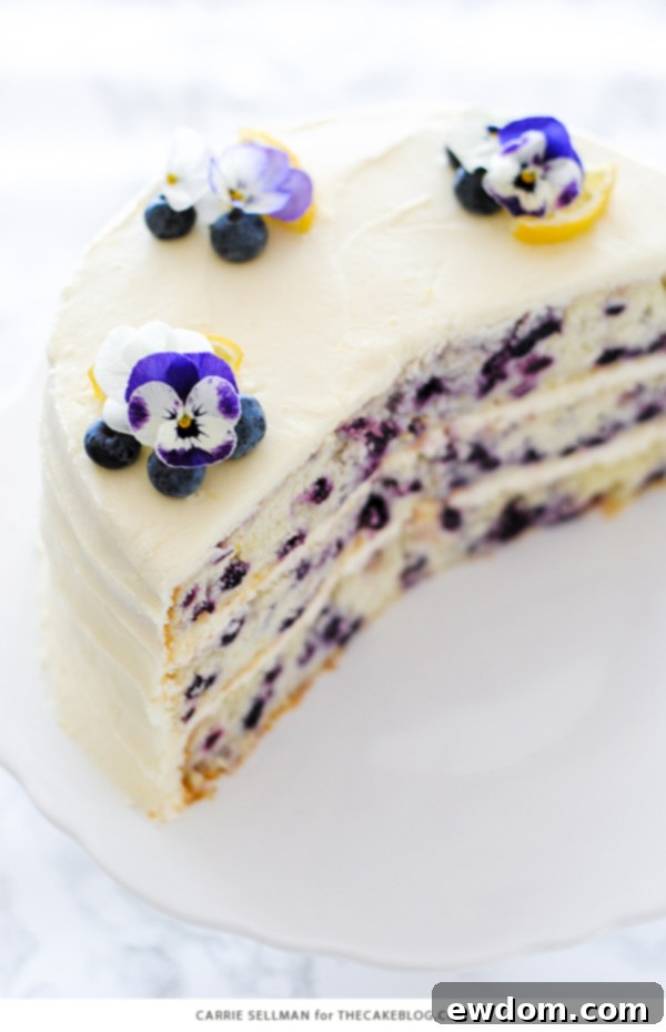 Lemon Blueberry Bliss 6 Side view of the Lemon Blueberry Cake, highlighting its three generous layers and thick lemon cream cheese frosting.