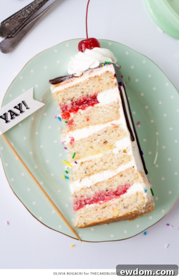 Ultimate Banana Split Cake 7 Decorated Banana Split Cake with chocolate ganache drips, sprinkles, whipped cream, and cherries, ready to serve | by Olivia Bogacki for TheCakeBlog.com