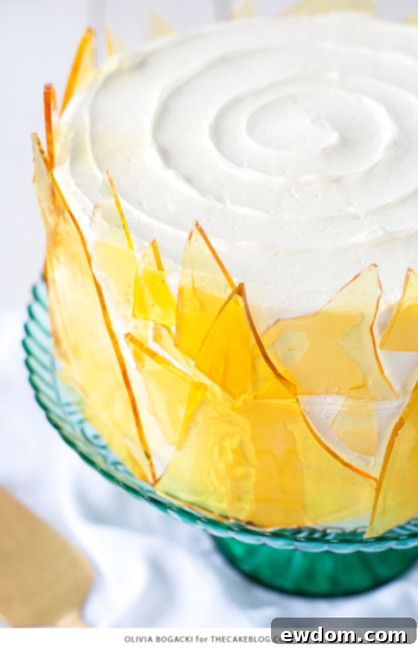 Caramelized Custard Dream Cake 5 Artfully decorated Crème Brûlée Layer Cake, showcasing its smooth buttercream and intricate caramel sugar shards, a recipe by Olivia Bogacki