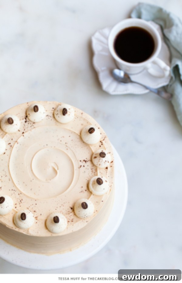 Caramel Cappuccino Cake - espresso cake paired with caramel buttercream frosting, topped with whole coffee beans and a sprinkle of cocoa powder | by Tessa Huff for TheCakeBlog.com