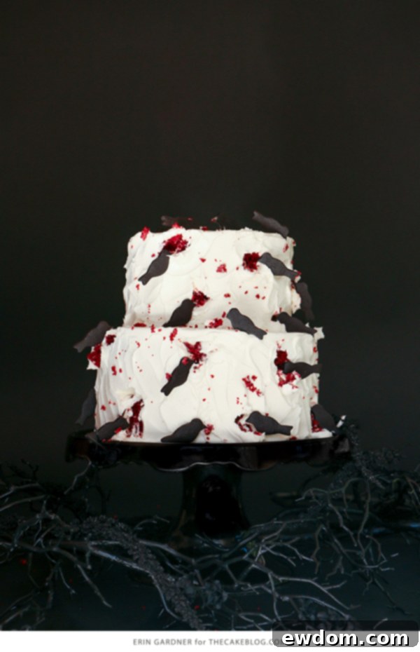 Hitchcock's The Birds inspired Halloween cake with attacking black bird cookies on red velvet