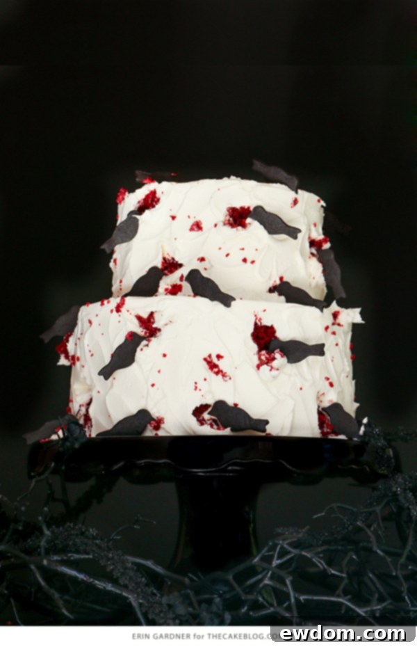 Overhead view of a two-tier cake decorated with menacing black bird cookies