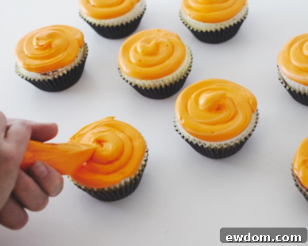 Piping Orange Frosting onto Black Cupcakes