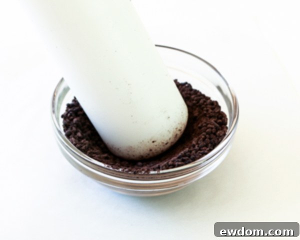 Crushing black jimmies sprinkles with a rolling pin for sunflower cake center