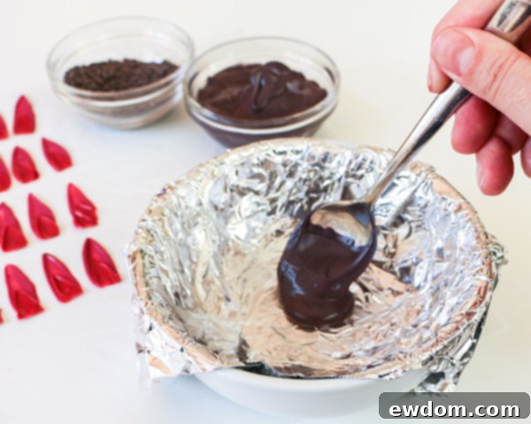 Pouring melted black chocolate into a foil-lined bowl for sunflower base