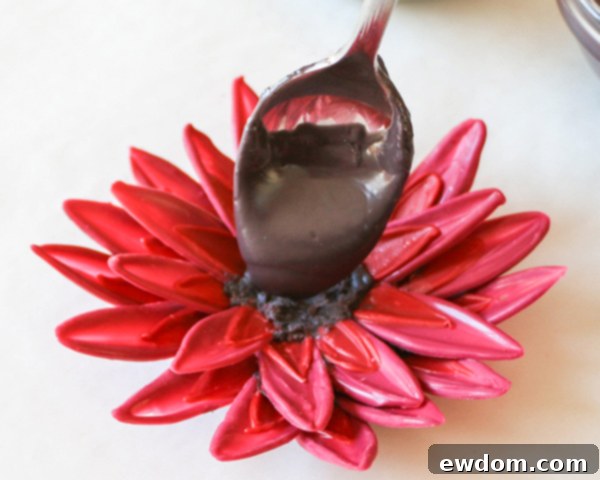 Adding melted black chocolate to the center of the sunflower, preparing for sprinkles