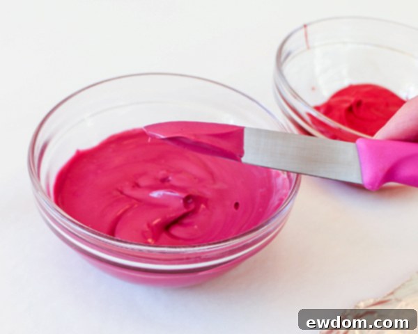 Knife dipping into purple melted chocolate to create a petal base for chocolate sunflower cake