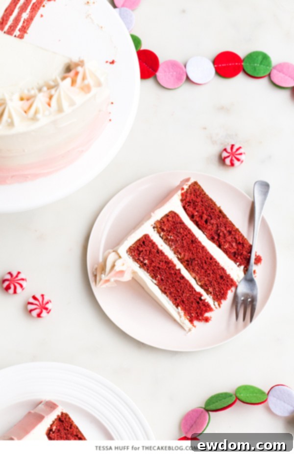 A festive Peppermint Red Velvet Cake with a rich red hue and creamy white chocolate peppermint frosting, perfect for winter