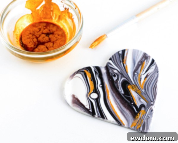 A collection of marbled chocolate hearts, beautifully adorned with dried gold luster dust accents, ready to be placed on a cake or cupcakes.