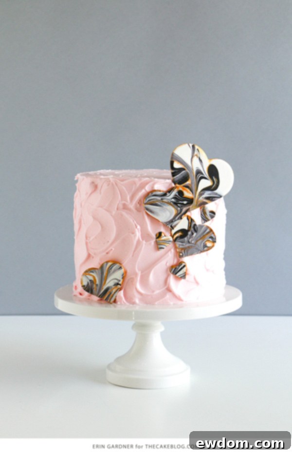 The finished cake, gracefully decorated with an assortment of marbled chocolate hearts, presenting a modern and sophisticated dessert design, a true labor of love.