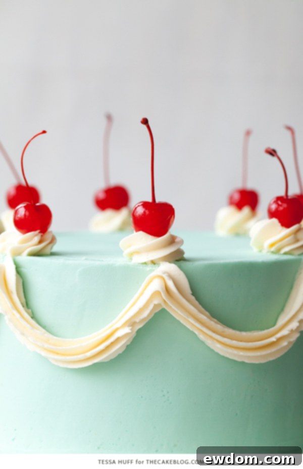 Cherry Chip Cake decorated with light blue frosting, white swags, and cherries