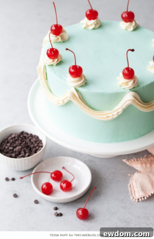 Side view of Cherry Chip Cake showing decorative piping and cherry toppings