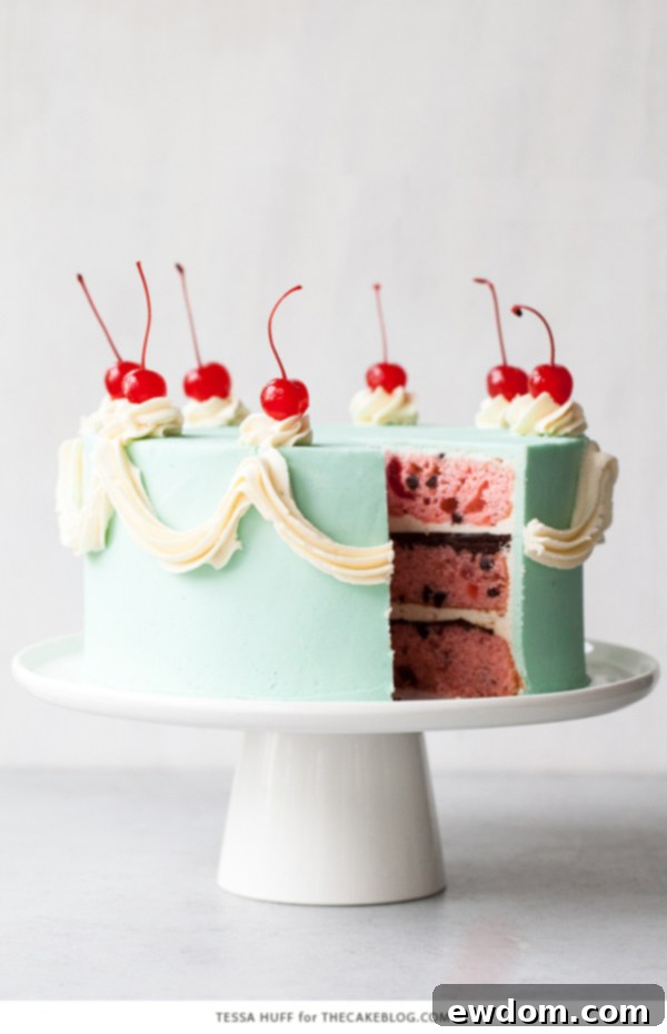 Slice of Cherry Chip Cake highlighting layers of cake, ganache, and frosting