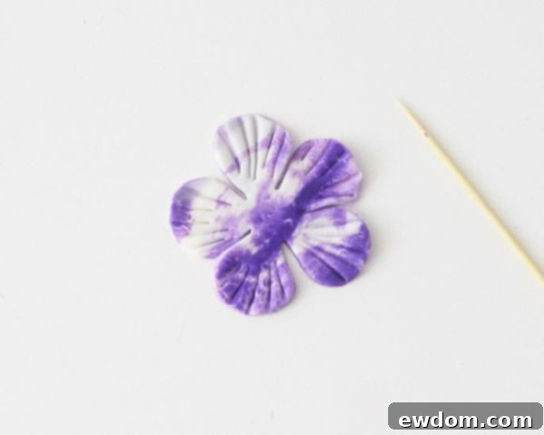 Using a toothpick to create indentations on fondant petals for cabbage texture