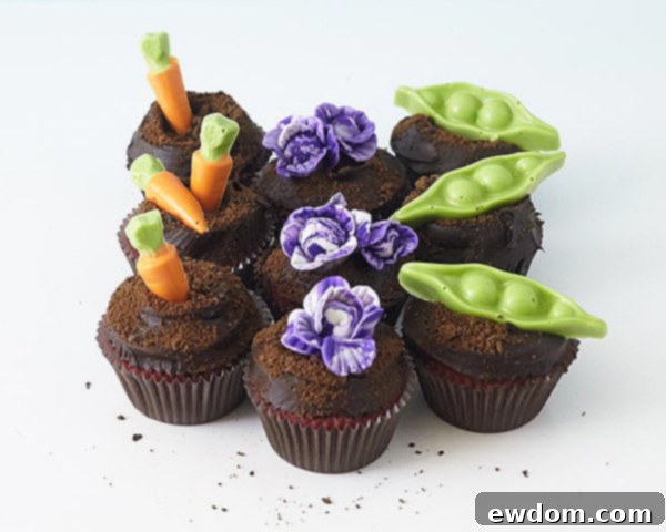 Assortment of handmade candy coating carrots, pea pods, and fondant cabbages for garden cupcakes