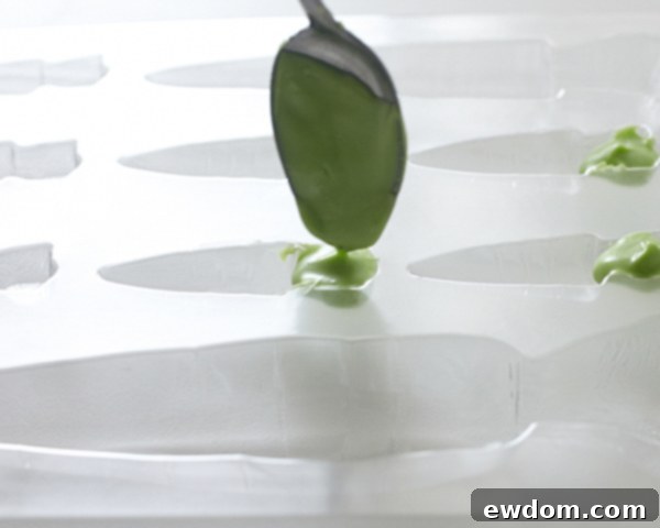 Filling carrot mold with green candy coating for the tops