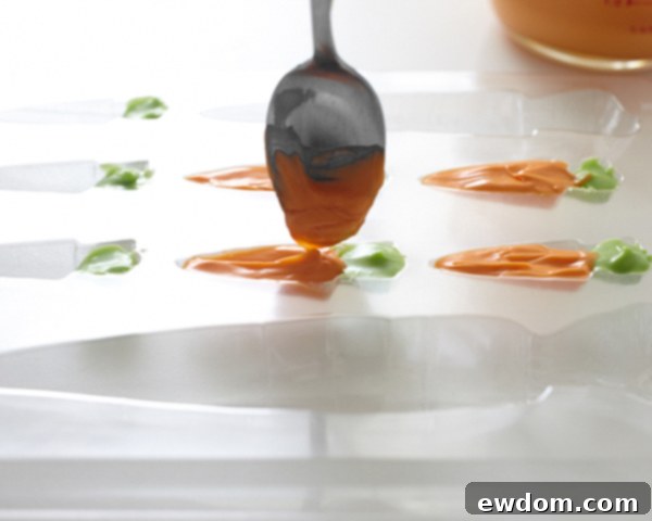 Filling carrot mold with orange candy coating, creating two-tone effect