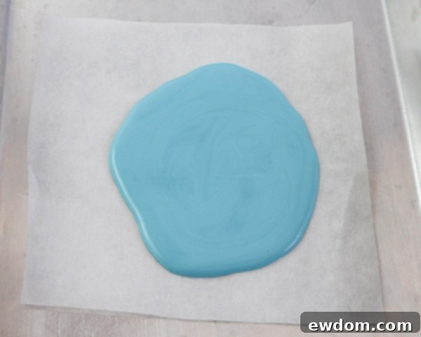 Elegant Swirl Easter Chocolates 11 Tapping a tray with piped chocolate to evenly spread and smooth the base layer, preparing it for marbling.