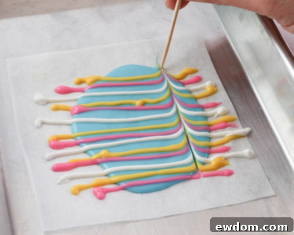 Elegant Swirl Easter Chocolates 14 Using a toothpick to drag through piped chocolate lines, creating an intricate marbled pattern for Easter egg toppers.