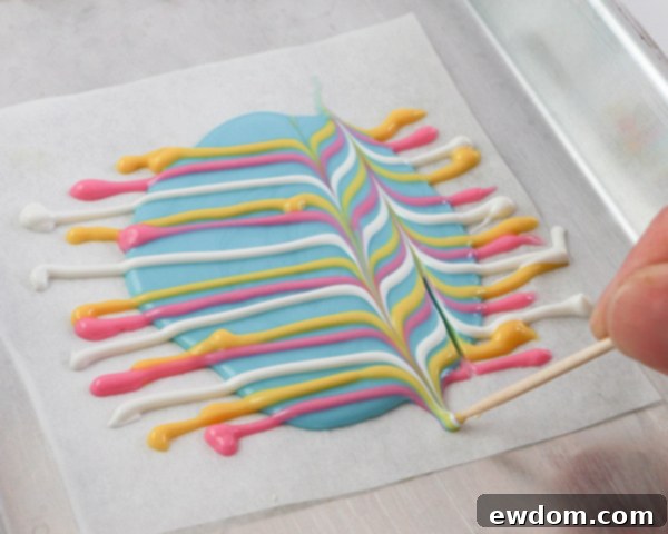 Elegant Swirl Easter Chocolates 15 Close-up of a toothpick creating swirls and patterns in multi-colored chocolate, achieving the marbled effect.