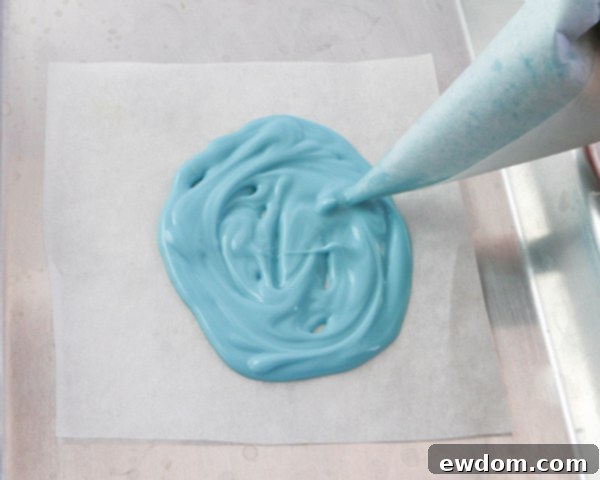 Elegant Swirl Easter Chocolates 10 Piping the first layer of colored coating chocolate onto a parchment paper template, filling in the egg outline.