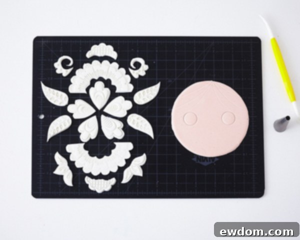 Matryoshka Magic Cake 17 Arranging fondant applique pieces and marking hair and eye details on the doll's face for the Russian nesting doll cake. Cake by Cakegirls.