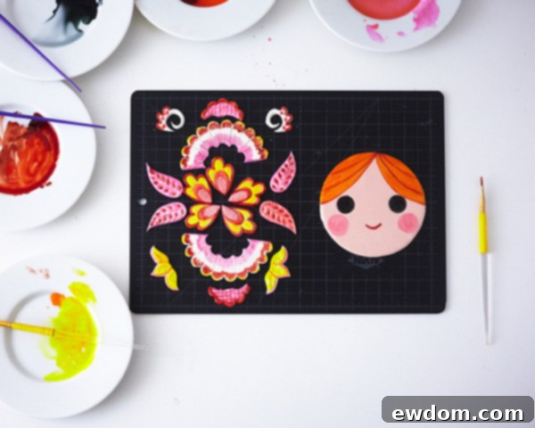 Matryoshka Magic Cake 19 Close-up of the painted face and applique details for the Russian nesting doll cake, showing vibrant watercolor effects. Cake by Cakegirls.