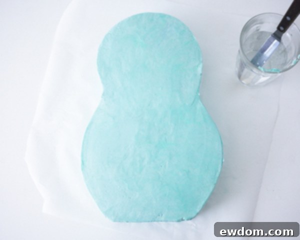 Matryoshka Magic Cake 10 Close-up of the perfectly smooth aqua buttercream finish on the Russian nesting doll cake before fondant application. Cake by Cakegirls.