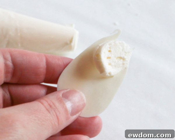 Applying small dabs of buttercream to the back of inner petals before attaching them to the cake for precise placement.