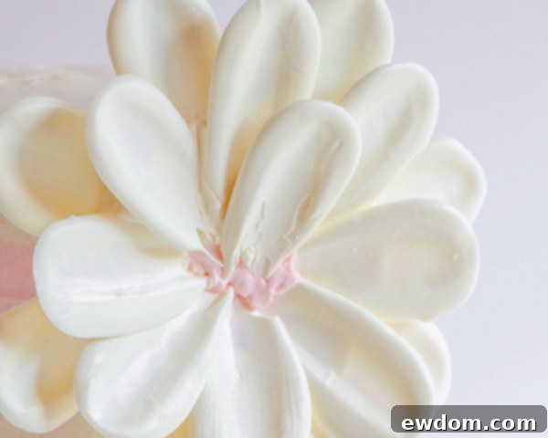 The inner row of white chocolate petals is carefully placed, building towards the center of the flower.