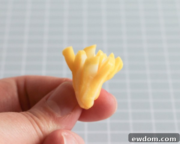 A close-up view of the bundled yellow taffy, ready to be inserted into the center of the white chocolate flower.