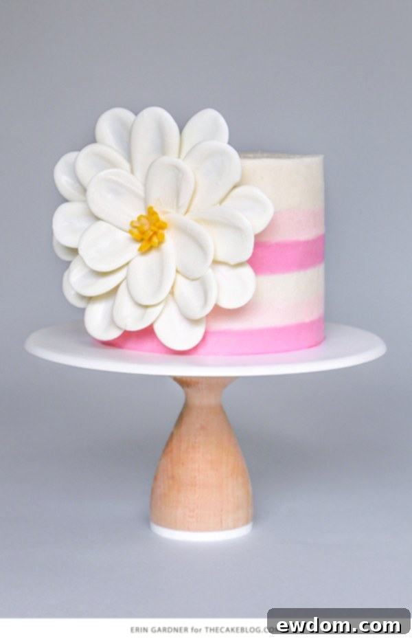 The finished White Chocolate Flower Cake, showcasing the elegant side statement bloom made with white chocolate and a yellow taffy center.