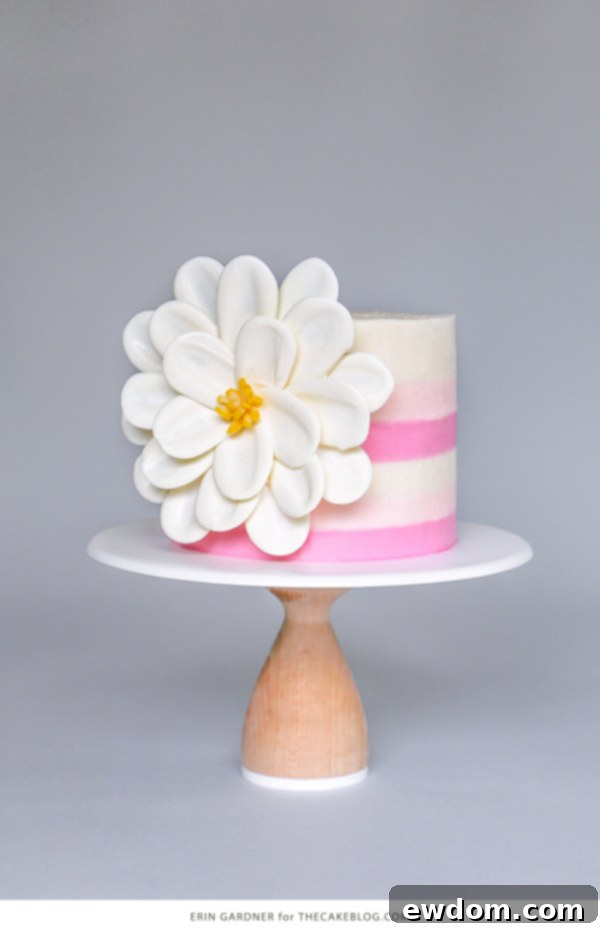 Close-up view of the white chocolate petals being formed on parchment paper, showcasing the simple technique using a spoon to spread melted chocolate.