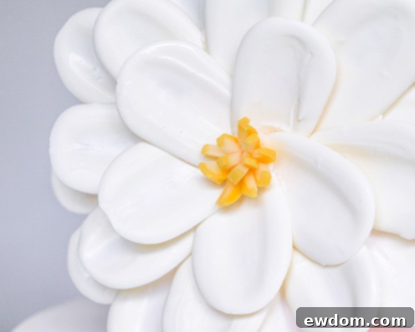 An overhead shot showcasing a variety of white chocolate petals laid out on parchment paper, ready for assembly into a stunning cake decoration.
