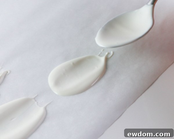 Several perfectly formed white chocolate petals are shown hardening on parchment paper, ready for assembly.