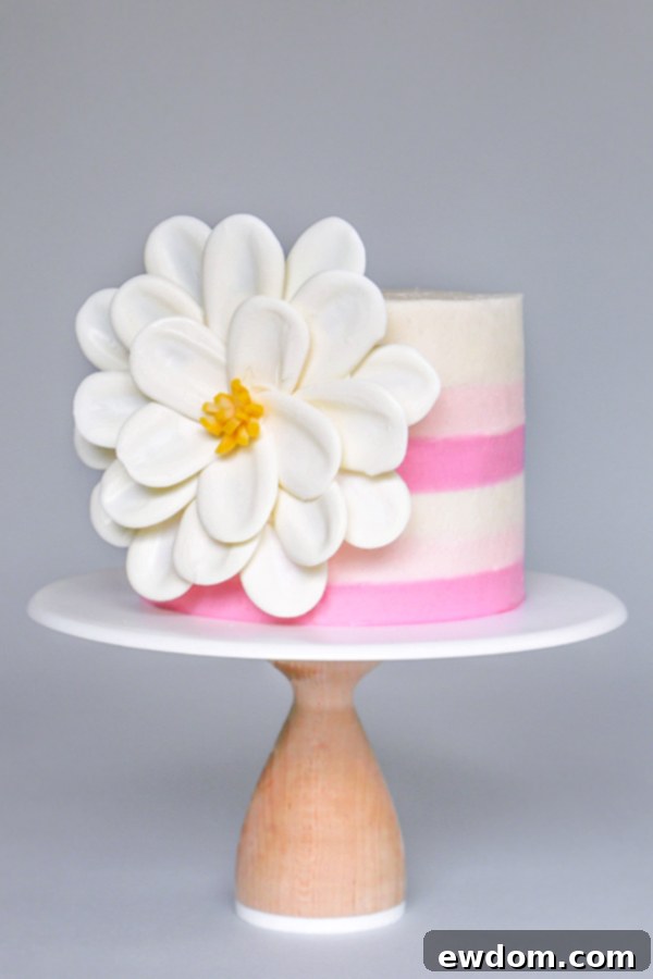 Elegant striped buttercream cake with a white chocolate flower decoration by Erin Gardner