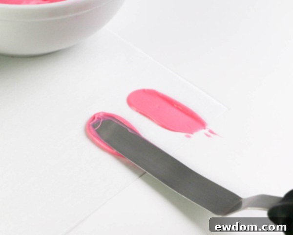 Pink Paradise Flamingo Cake 11 Demonstrating the technique for light pink chocolate brushstroke feathers