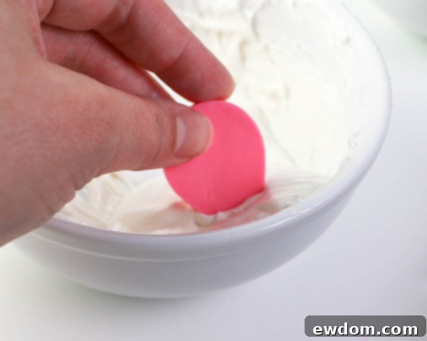 Pink Paradise Flamingo Cake 18 Dipping the pointed end of the small pink tear drop into melted white chocolate for the beak