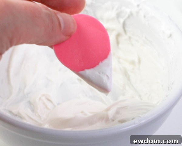 Pink Paradise Flamingo Cake 19 Carefully smoothing excess white chocolate from the beak with fingers for a clean finish