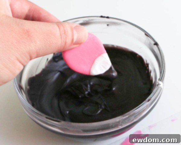Pink Paradise Flamingo Cake 21 Dipping the tip of the white chocolate beak into melted black chocolate for the distinctive black tip