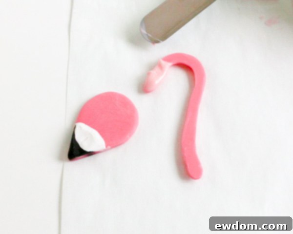 Pink Paradise Flamingo Cake 22 Attaching the finished flamingo head to the neck using melted pink chocolate as adhesive