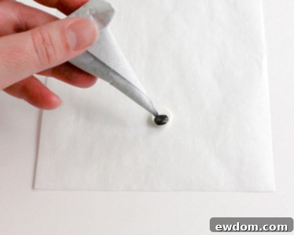 Pink Paradise Flamingo Cake 23 Piping a black chocolate dot onto the white chocolate circle to create the flamingo's eye