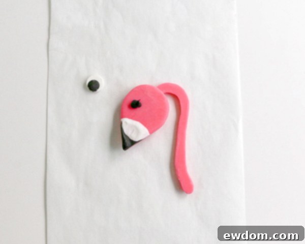 Pink Paradise Flamingo Cake 24 Applying a small dot of black chocolate to adhere the eye to the flamingo's head