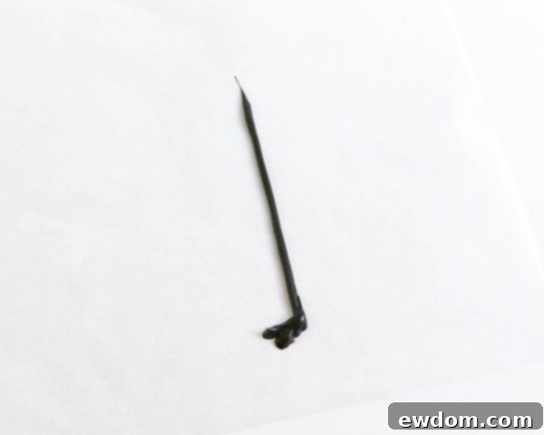 Pink Paradise Flamingo Cake 27 Piping melted black chocolate to form the straight flamingo leg with foot details